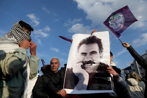 A demonstrator holds a picture of jailed Kurdish militant leader Ocalan